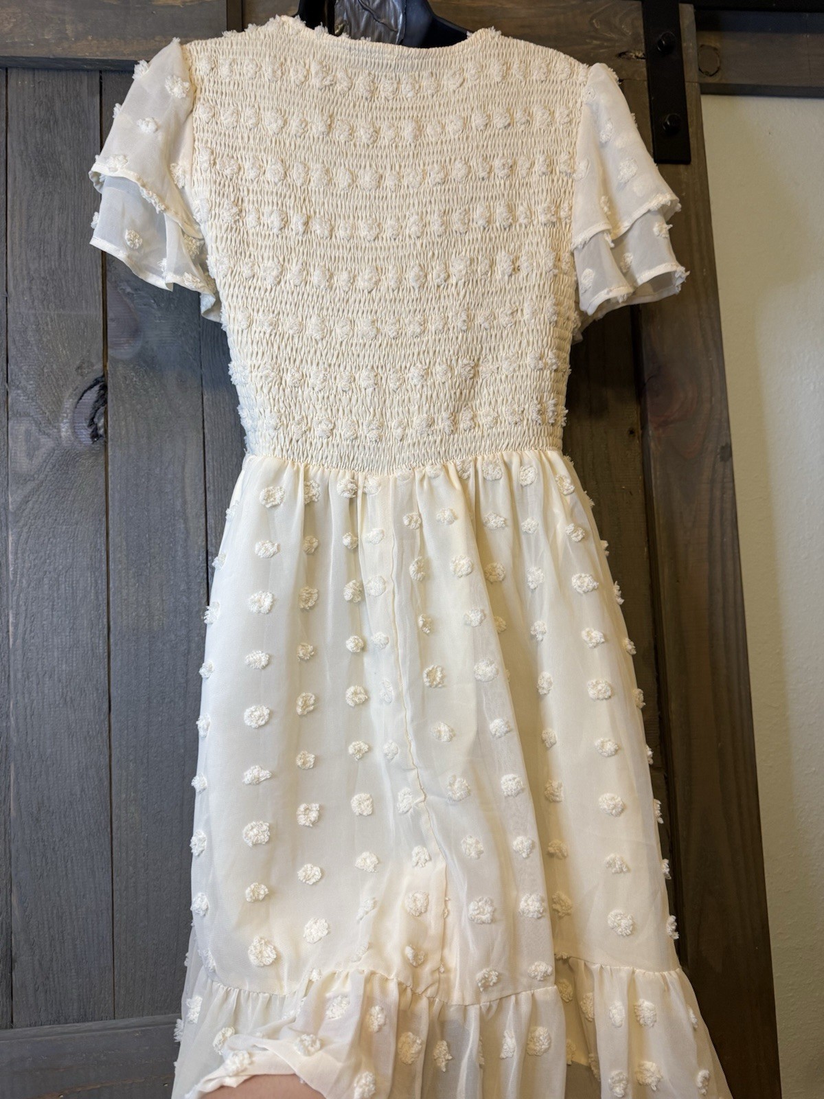 White midi Swiss dot mini dress features a smocked bodice and layered ruffle