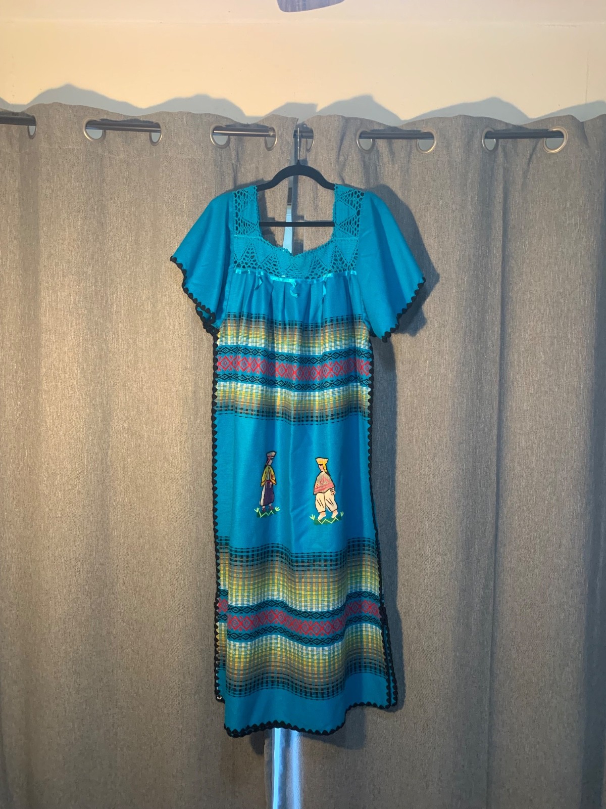 Blue and green striped dress with embroidered details.