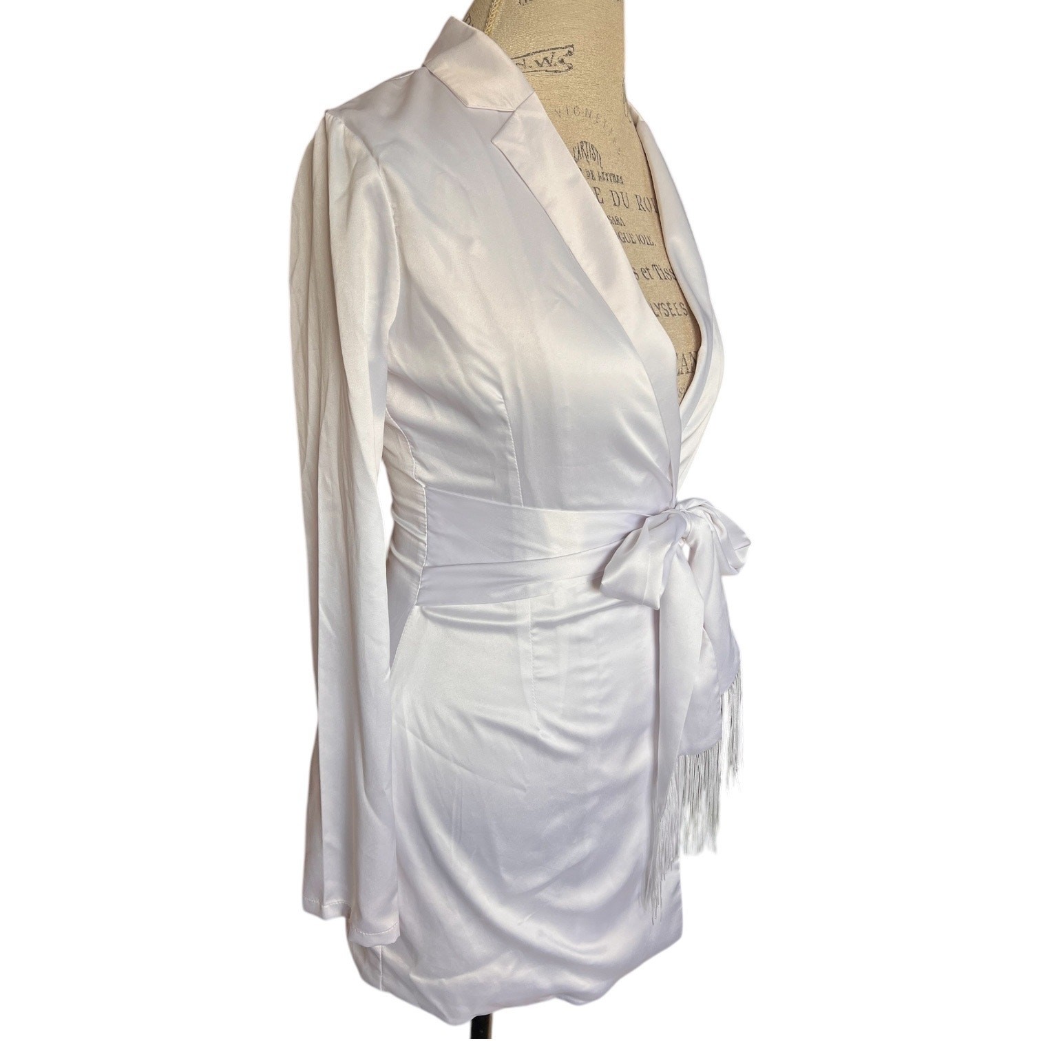 More To Come collared long sleeve mini dress. Tasseled tie belt, snap up, white