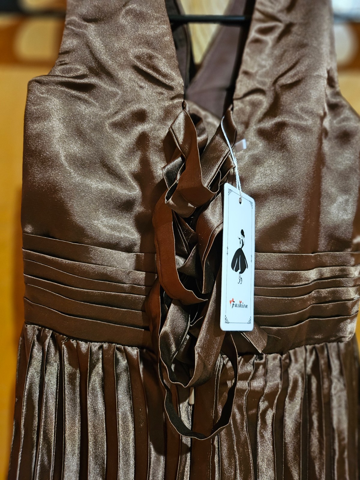 This stunning halter neck dress features a beautiful pleated skirt. It has a gat