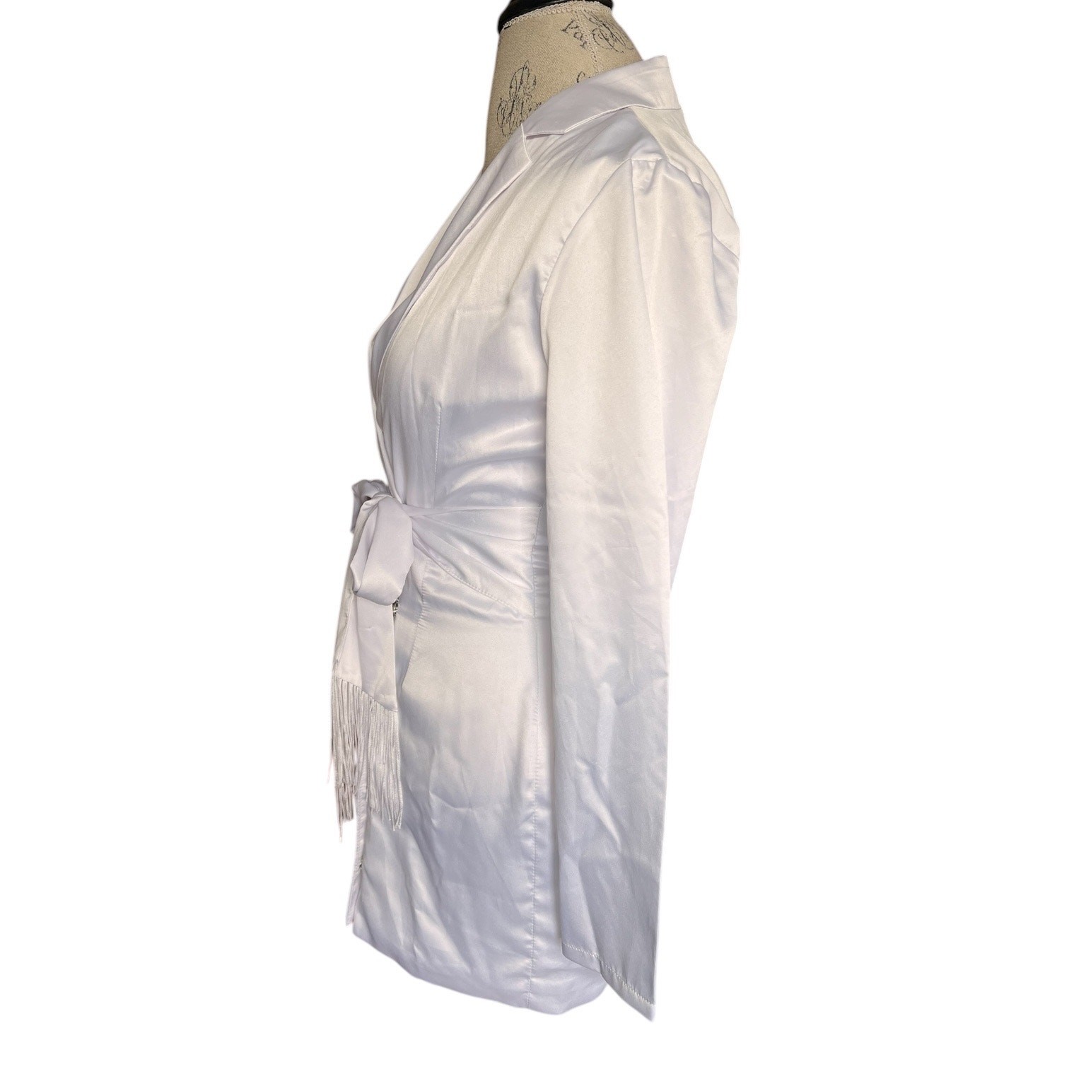 More To Come collared long sleeve mini dress. Tasseled tie belt, snap up, white