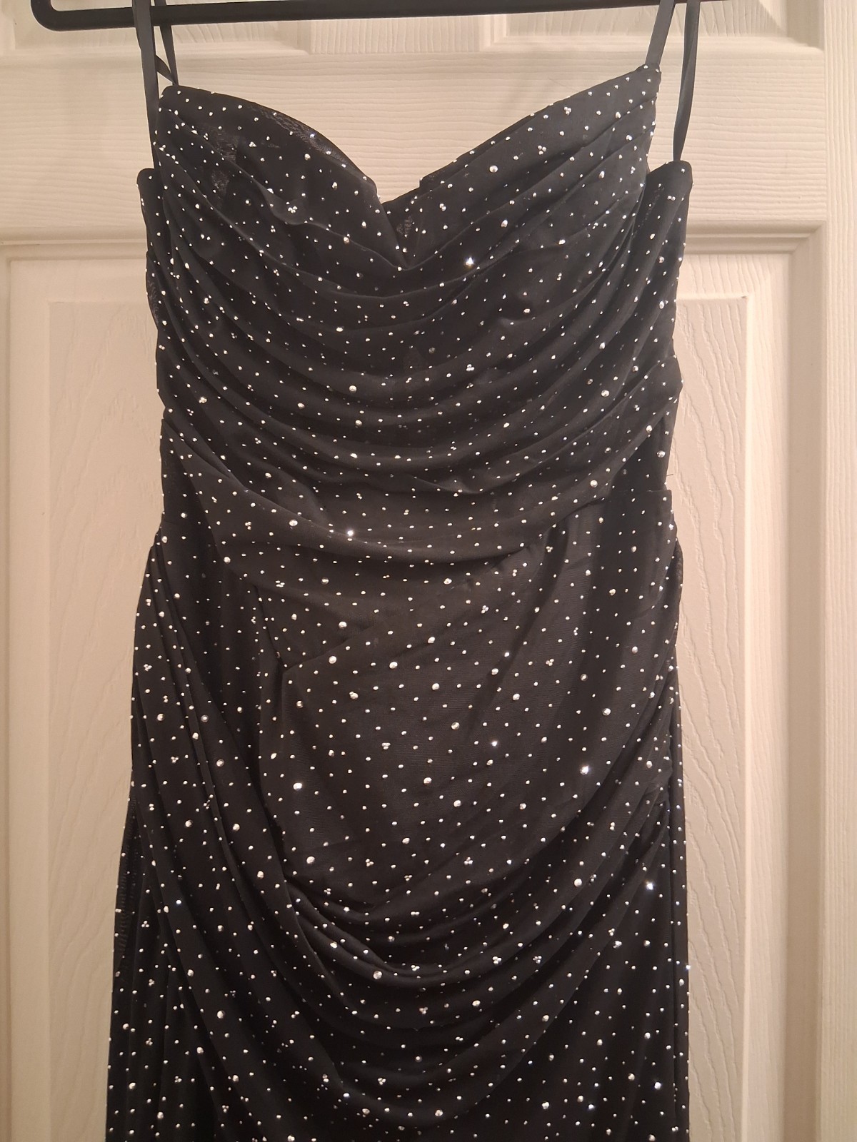 Black dress adorned with rhinestones,High thigh-slit and open back piece