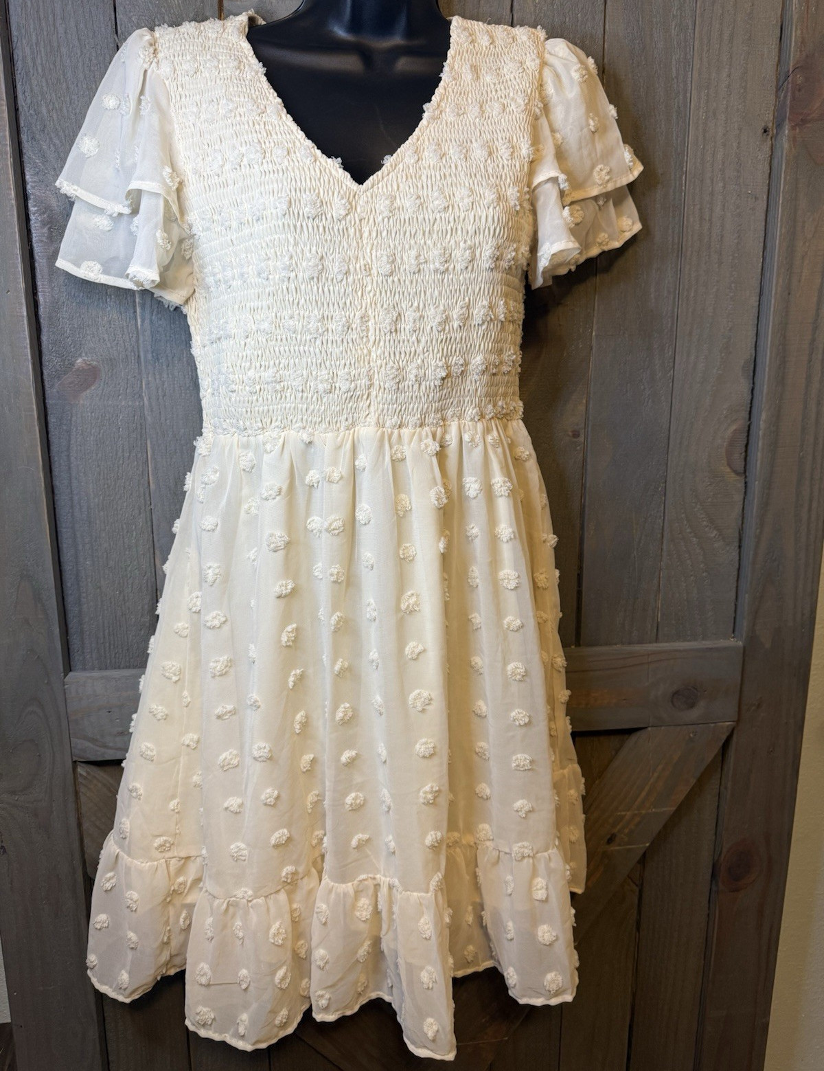 White midi Swiss dot mini dress features a smocked bodice and layered ruffle