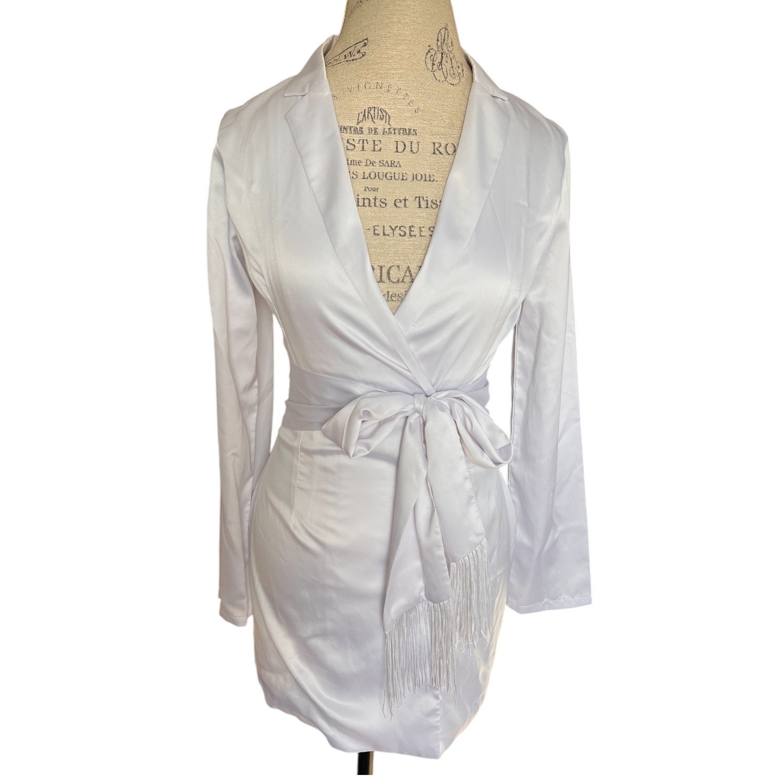 More To Come collared long sleeve mini dress. Tasseled tie belt, snap up, white
