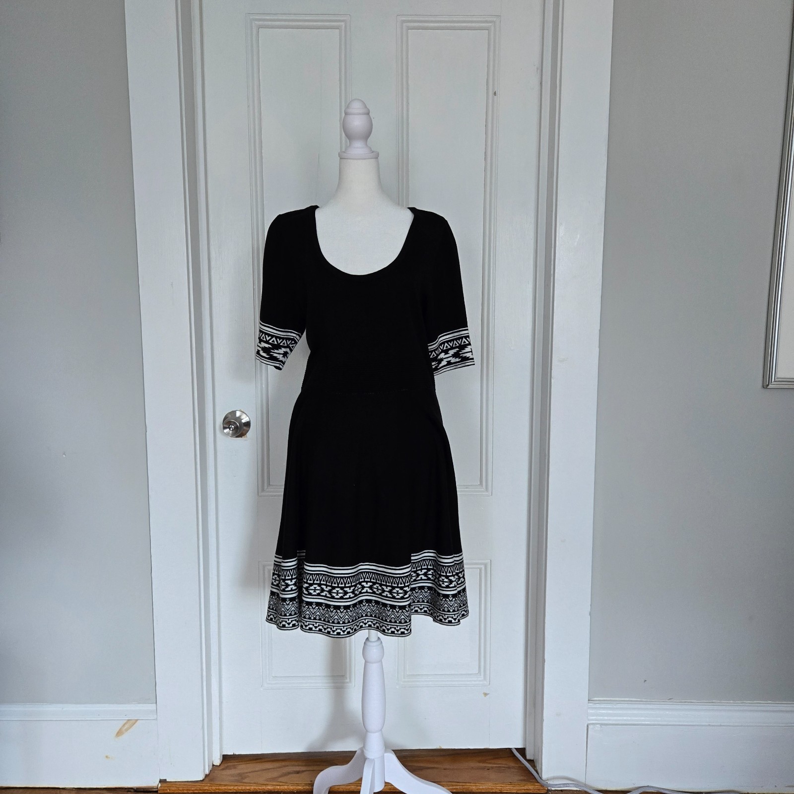 Nina Leonard black knit dress with fitted waist and white geometric pattern