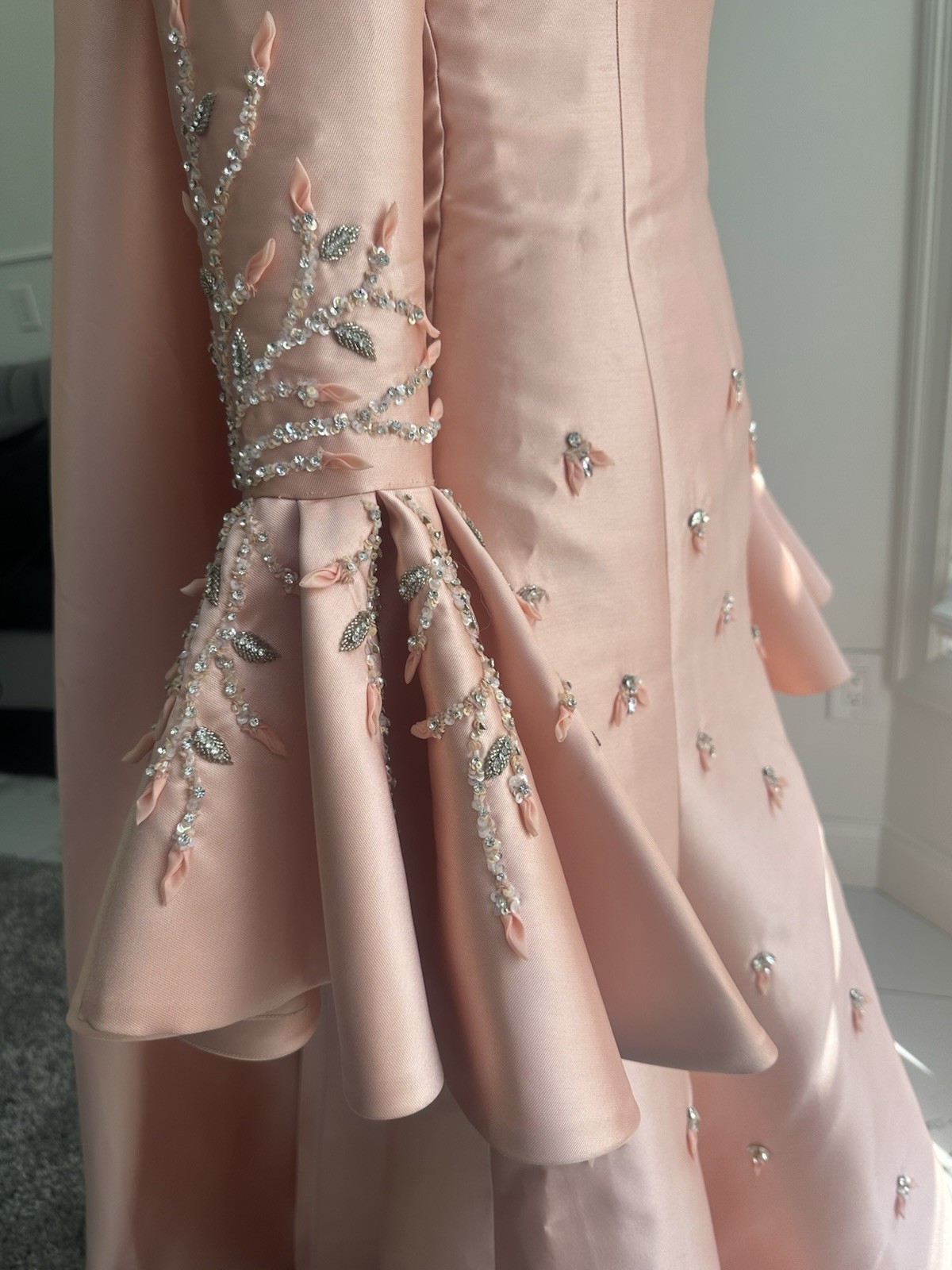 Blush-peach silk gown with floral sleeves, soft drama, and timeless elegance.