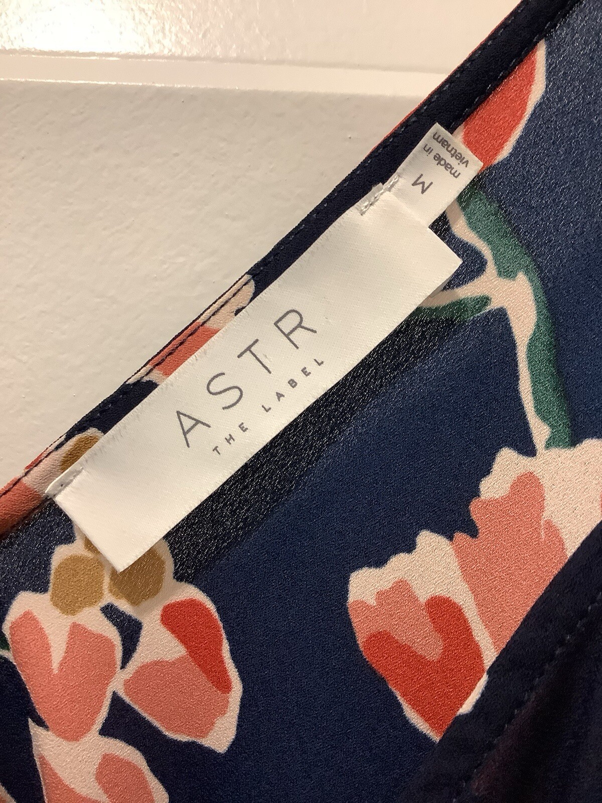 ASTR SUN ROMPER, FLORAL PRINT ON NAVY BACKGROUND, CAN BE WORN CASUAL OR DRESSY.